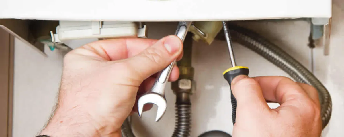 Boiler repair technician tightening pipe fittings and connections in Boise, ID