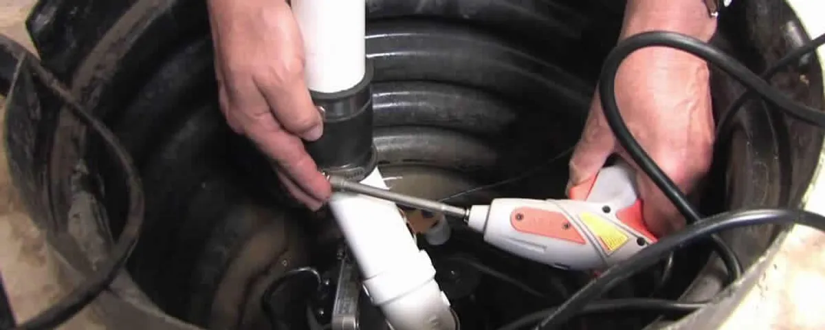 Sump pump installation technician connecting PVC discharge piping in Boise, ID