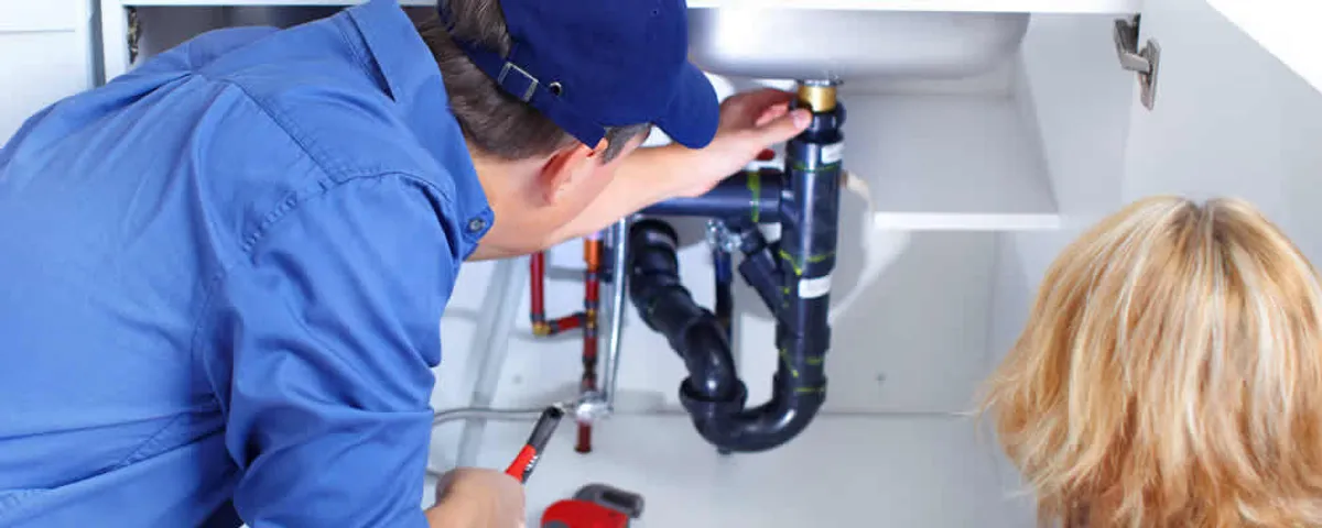 Plumber repairing under-sink drain pipes and fittings in Boise, ID
